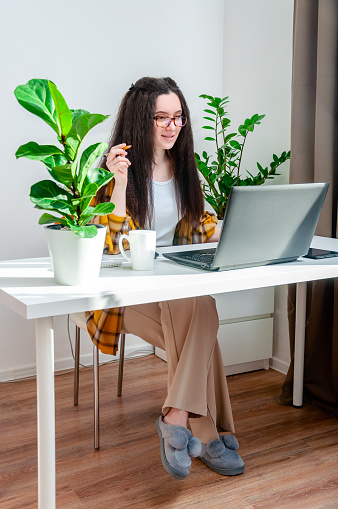 Beautiful woman in glasses talking on the video call on a workplace. Woman working at home,holds a conference, conducts a training or webinar.