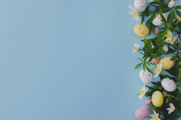 istock Colorful Easter chocolate eggs and spring flowers border on blue background, flat lay with space for text. Stylish easter greeting card template. Happy Easter! 1379294361