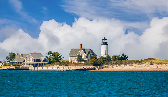 The lighthouse and cottage colony at the tip of Sandy Neck peninsula in Barnstable, Massachusetts