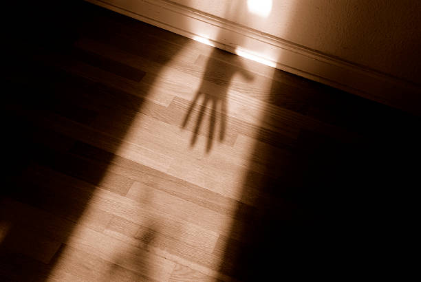 Spooky shadow Spooky shadow of hand of person (could be a burglar, for instance) entering a hallway (only lit by the incoming sunlight).  sexual assault stock pictures, royalty-free photos & images