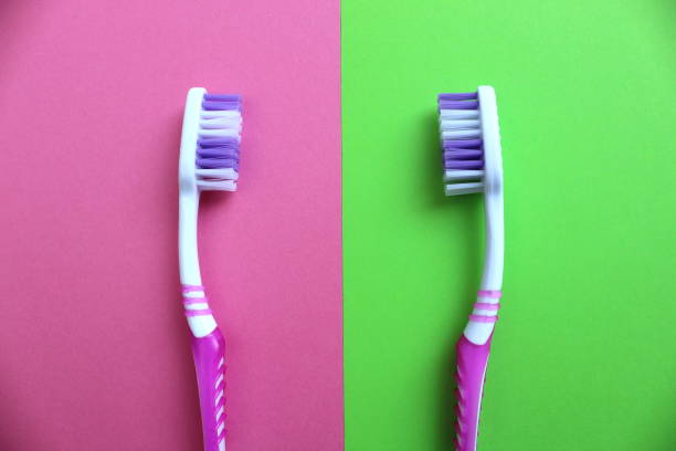 istock Two toothbrushes are against each other on a different background 1379304670