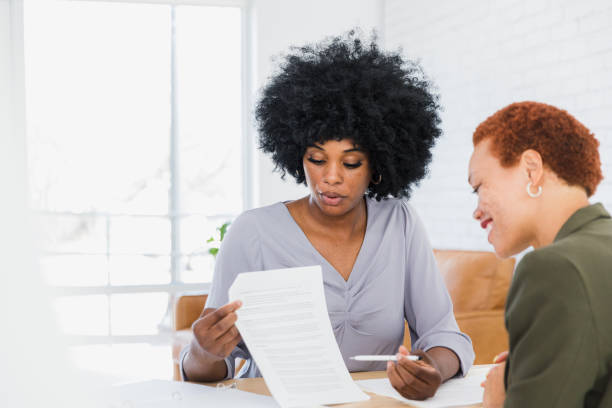 istock Female real estate agent explains contract to smiling female client 1379309306