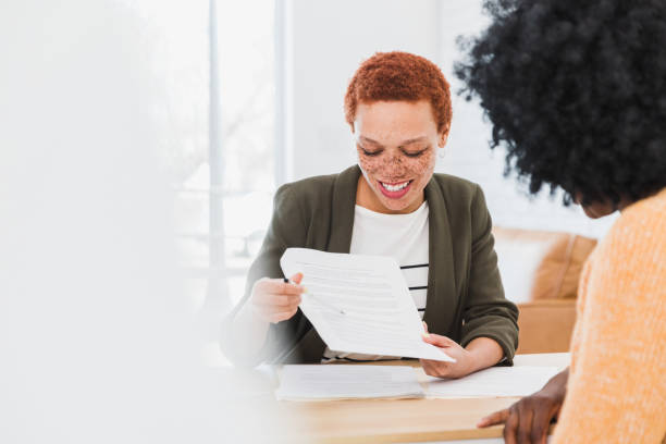 istock Female financial advisor explains document to unrecognizable woman 1379309410