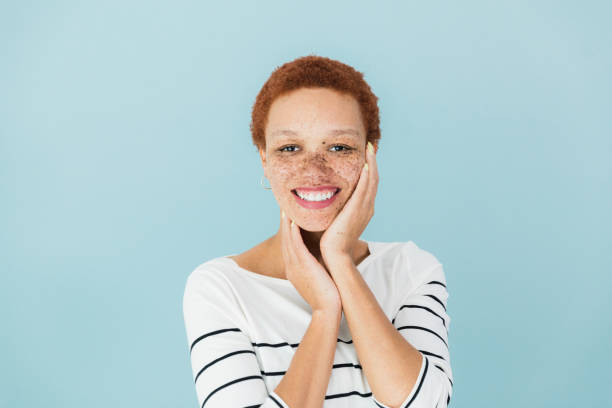 istock Beautiful, smiling woman holds face in hands 1379309885