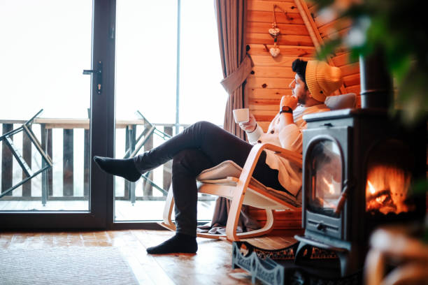 istock Casually Dressed Businessman is Resting By The Fireplace At Home And Drinking Coffee , Man Lifestyle 1379312096