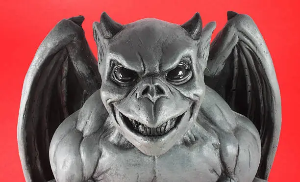 Gargoyle bust with wings over a red background