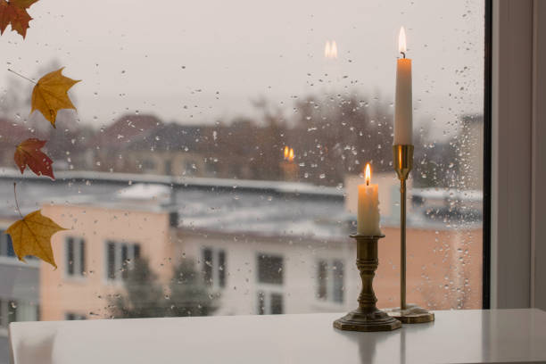burning candles on background rainy window pane