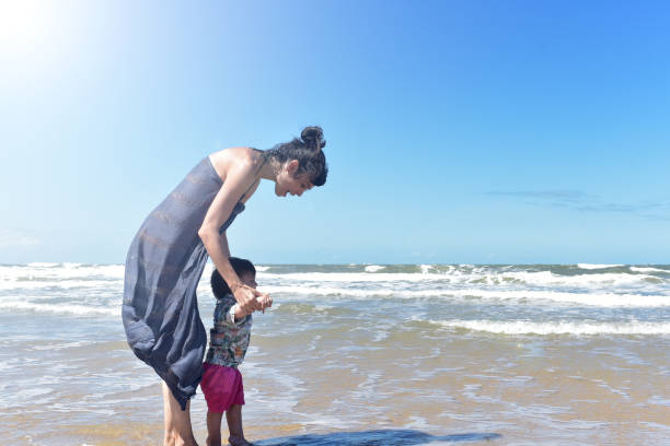 istock madre jugando con su hijo en la playa 1379371243