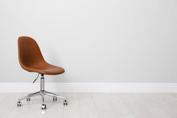 istock Comfortable office chair near light wall indoors. Space for text 1379378136
