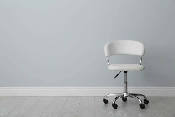 istock Comfortable office chair near light wall indoors. Space for text 1379379179