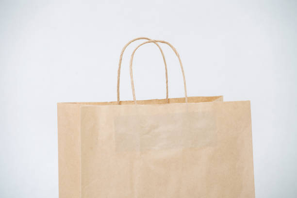 istock Cropped image of empty brown paper bag with rope handles over white background 1379379724
