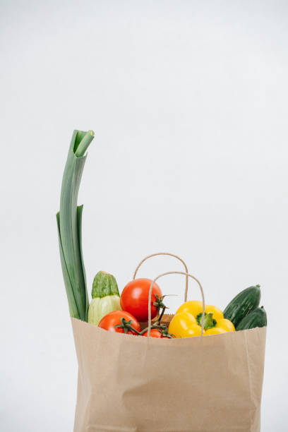 istock Grocery paper bag filled with colorful vegetables over white background. 1379379733