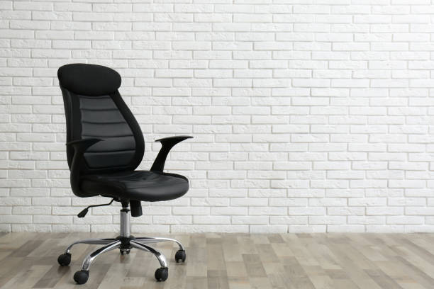 istock Comfortable office chair near white brick wall indoors. Space for text 1379380277