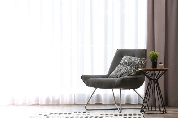 istock Comfortable chair near window with elegant curtains in room. Space for text 1379381388
