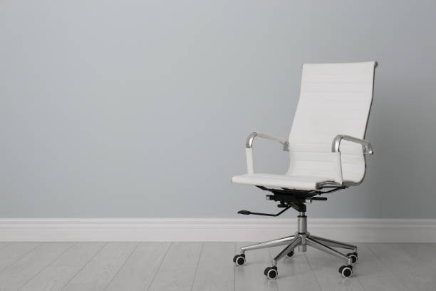 istock Comfortable office chair near light wall indoors. Space for text 1379381428