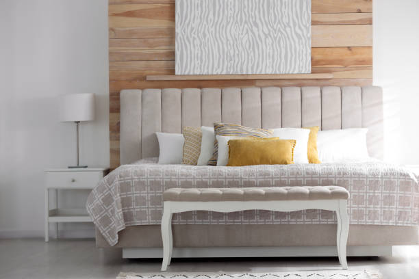Comfortable bed with soft color pillows indoors