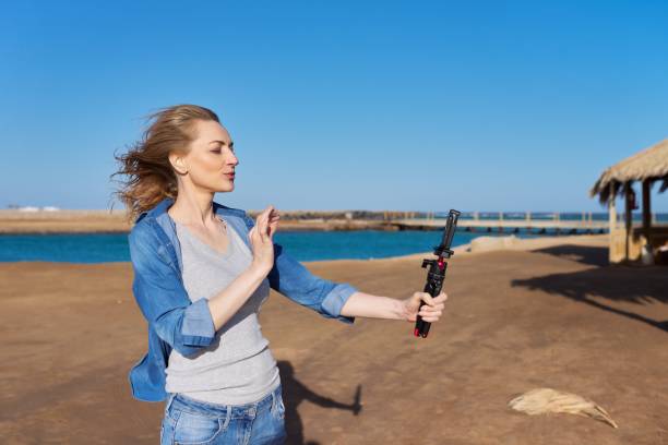 Mature woman recording video on smartphone, making a stream