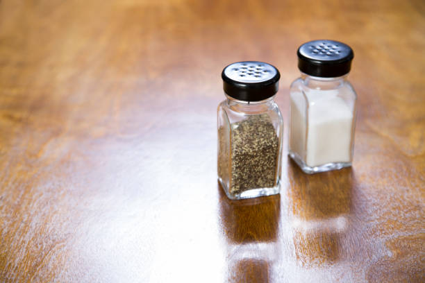 Salt and pepper shakers on a wooden table.