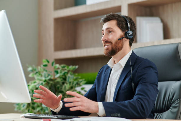 istock Representive practitioner leads online training wearing a suit and headset, with positive vibes and active gestures and explanations 1379412292