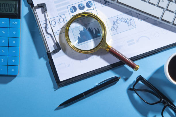 istock Business graphs, calculator, computer keyboard, pen, magnifying glass. 1379412812