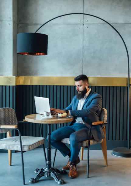 istock Handsome Businessman Having Coffee and Cake while Working in a Cafe on his Laptop Computer 1379434896