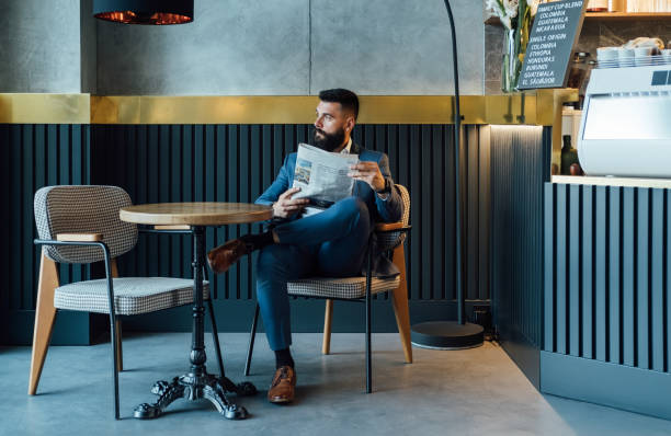 belo empresário lendo jornal em um café - table restaurant chair people - fotografias e filmes do acervo