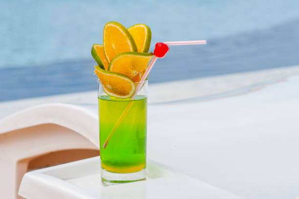 istock Green drink with orange and cherries by the pool with blurred background. 1379436722