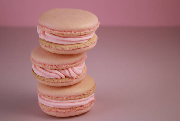 pink macaroons with pink strawberry buttercream on pink background