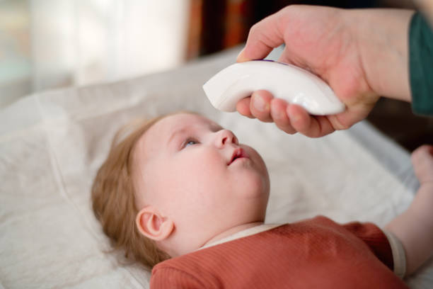istock Father measuring temperature of his baby girl with digital thermometer 1379450220