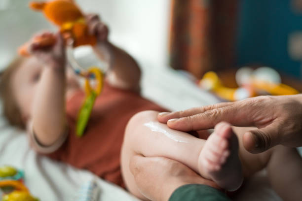 father applying moisturizing and protective cream to his baby girl - applied science imagens e fotografias de stock