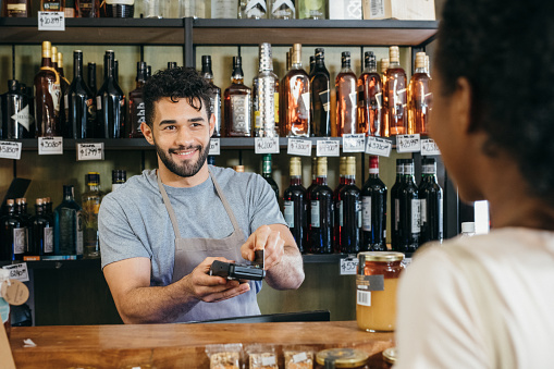 Customer paying contactless at delicatessen store