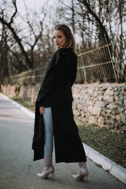 istock Pretty young woman in black coat poses 1379477629