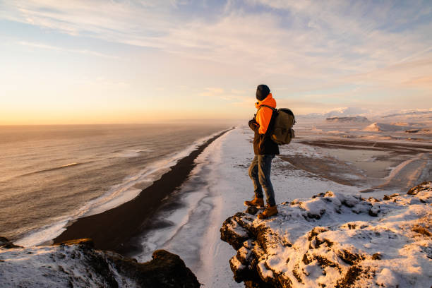 der tourist beobachtet die isländische landschaft beim sonnenuntergang - wilderness area stock-fotos und bilder