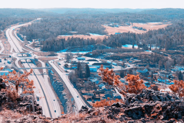 Bamble, Norway- march 2, 2022. European Route E18 highway between Oslo and Kristiansand. Car passing. View from the rock above the road, blurred foreground.