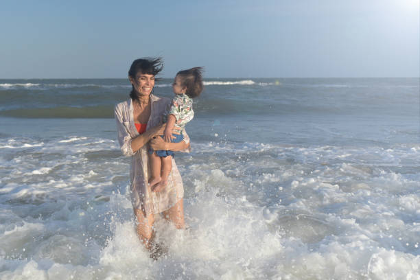 istock mother with her child playing on the beach 1379501396