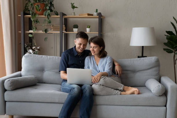 istock Happy dating couple relaxing on comfortable sofa at computer 1379515653