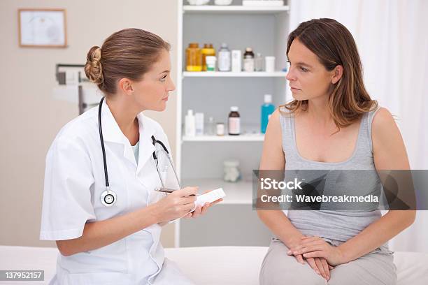 Doctor Taking Notes Stock Photo - Download Image Now - Discussion, Doctor, Patient