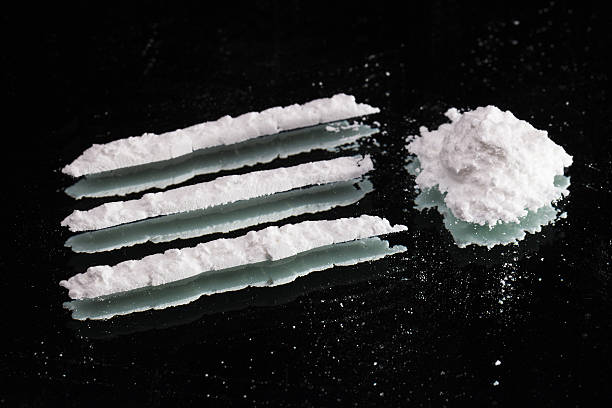 Cocaine drugs heap and lines still life on dark mirror stock photo