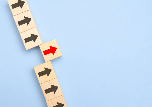 istock Wooden block with red arrow facing the opposite direction black arrows, Unique, think different, individual and standing out from the crowd concept 1379568112