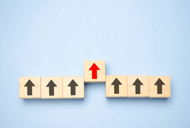 istock Wooden block with red arrow facing the opposite direction black arrows, Unique, think different, individual and standing out from the crowd concept 1379568171
