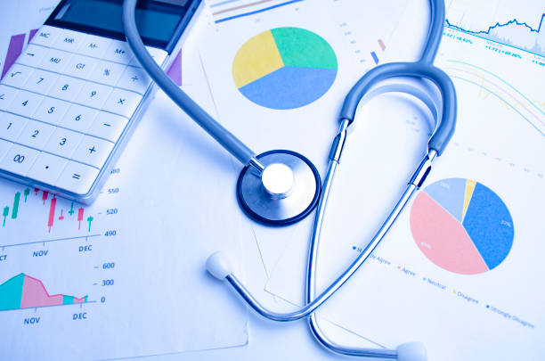Medical practice financial analysis charts with stethoscope and calculator. Close up stock photo