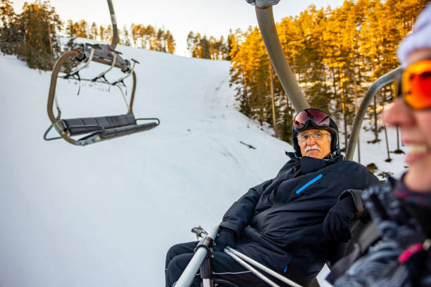 istock Senior male ski instructor, riding at the cable car with a female student 1379603097