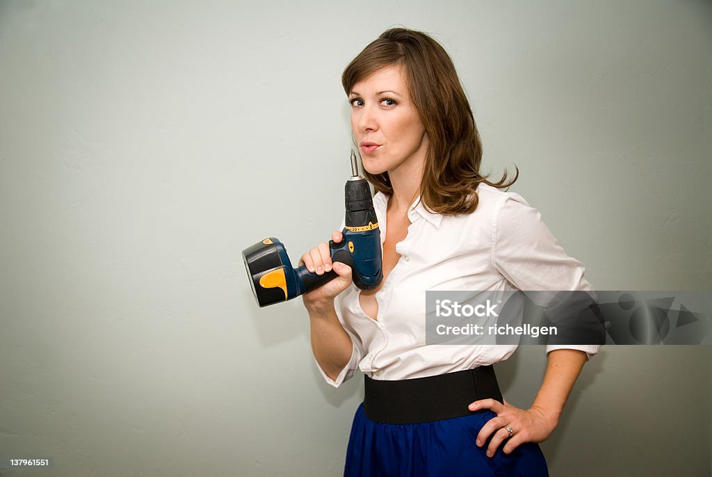 Woman holding drill Attractive retro woman blowing on drill like a gun. Horizontal image with copy space. Achievement Stock Photo