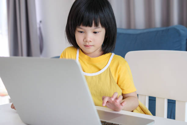 istock little asian girl student study online using laptop computer at home 1379620310