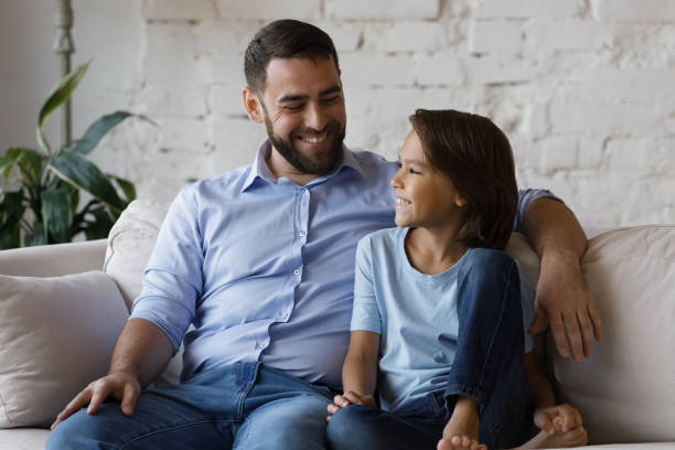 istock Cheerful dad talking to happy adopted son kid 1379620845