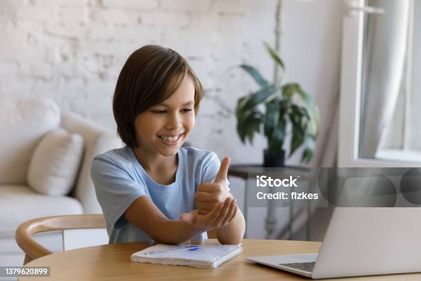 Smiling Boy With Hearing Disability Studying Online From Home Stock Photo - Download Image Now