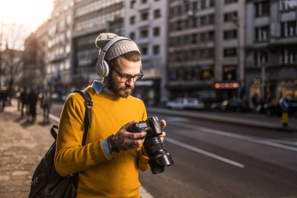 Young photographer taking photos of the city with professional camera.