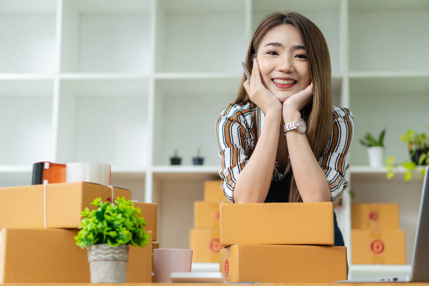 Young Asian Women Start Small Business Successful SME Entrepreneur .freelance Work-at-home woman with the laptop to take orders and deliver parcels online. SME delivery concept and packaging las mujeres jóvenes asiáticas inician una pequeña empresa pyme exitosa empresaria .freelance mujer que trabaja en casa con la computadora portátil para tomar pedidos y entregar paquetes en línea. concepto de entrega y embalaje para pymes