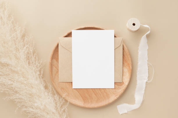 istock Blank greeting card invitation Mockup on Brown envelope with pampas grass on beige background, Minimal table workplace composition, flat lay, mockup 1379752548