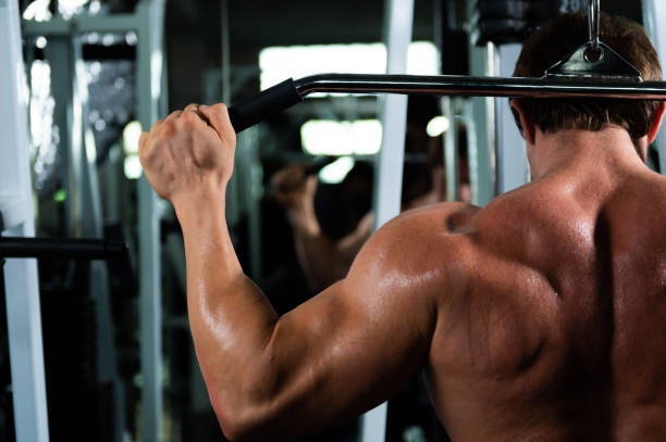 istock Caucasian man bodybuilder pulling weight lifting machine at gym. 1379776383